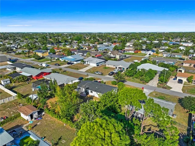 Aerial view of property and surrounding area with nearby suburban area