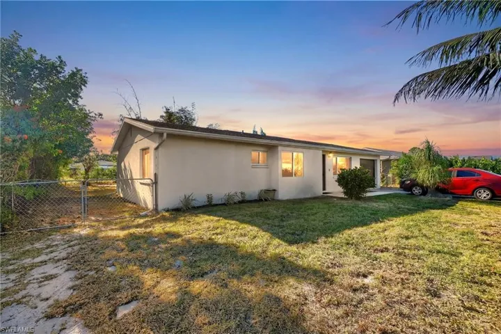 View of front of home featuring stucco siding and a gate