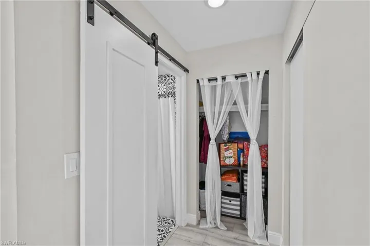 Corridor featuring a barn door and baseboards