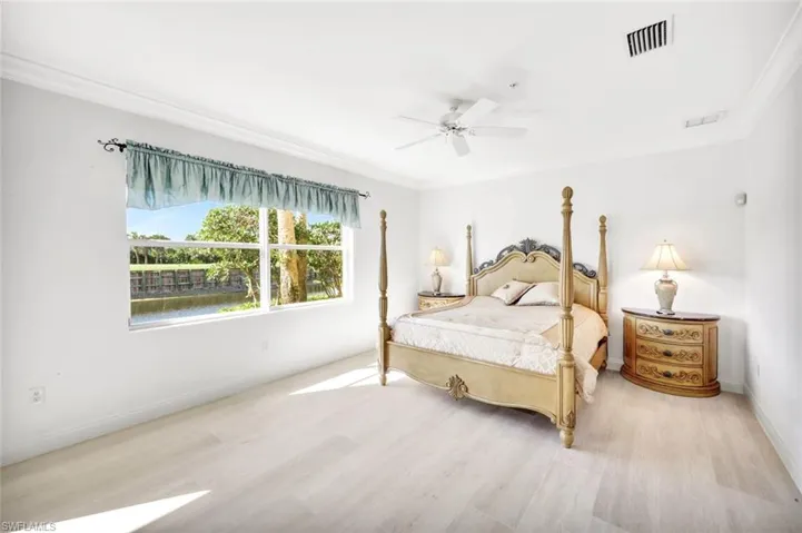 Spacious primary bedroom with crown molding, tile floors and an amazing view!