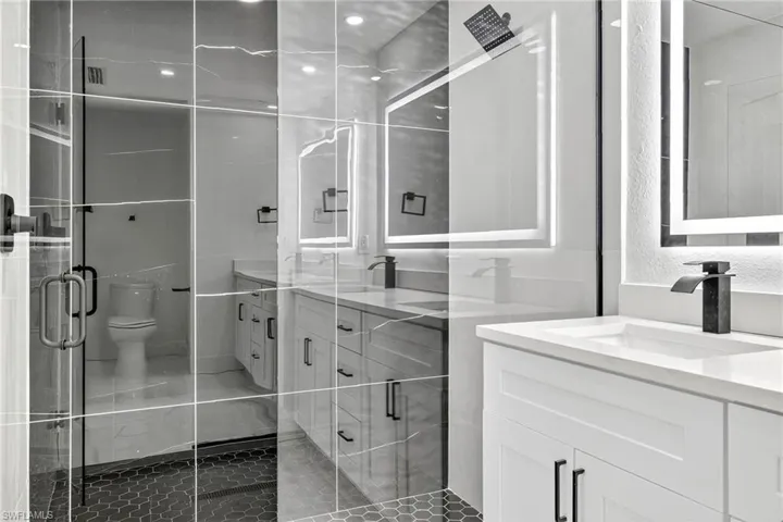 Bathroom featuring vanity, tile patterned flooring, and a shower stall