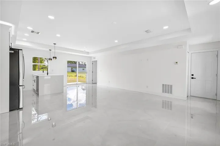 Unfurnished room featuring a tray ceiling and recessed lighting