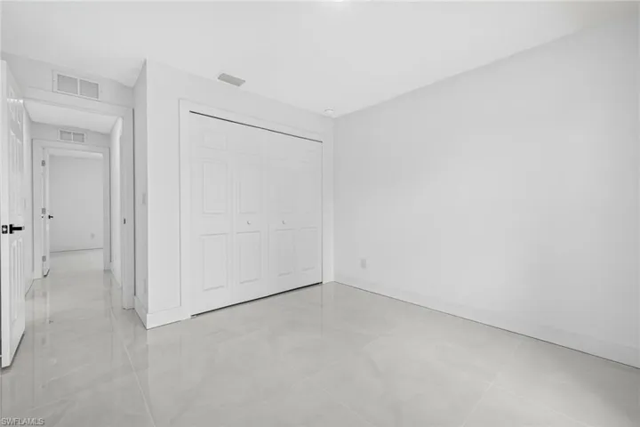 Unfurnished bedroom featuring light tile patterned flooring and a closet