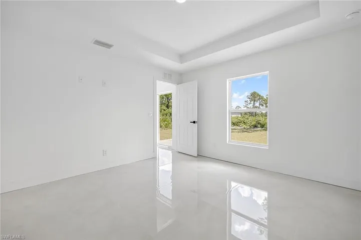 Spare room with a tray ceiling and light tile patterned flooring