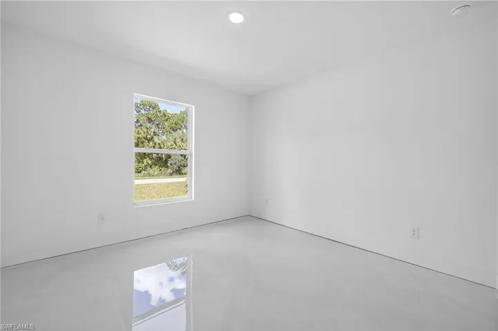 Tiled empty room featuring recessed lighting