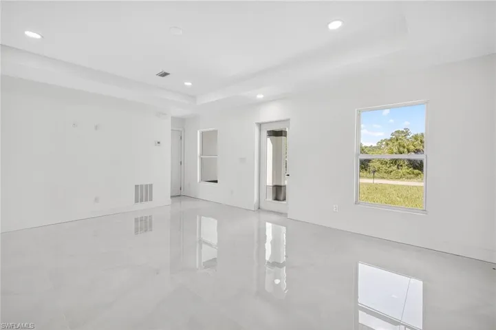 Empty room featuring a tray ceiling and recessed lighting