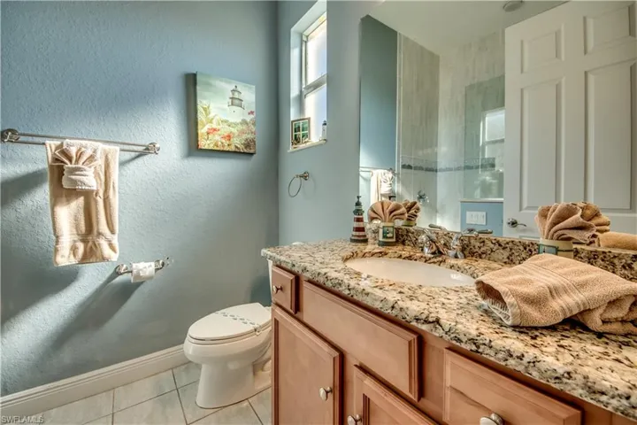 Bathroom featuring toilet, vanity, and tile patterned floors