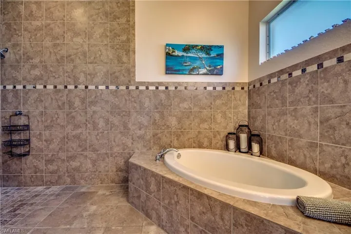 Bathroom featuring tile walls and tiled tub