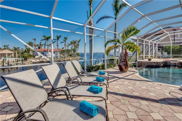 View of patio / terrace featuring glass enclosure and a water view
