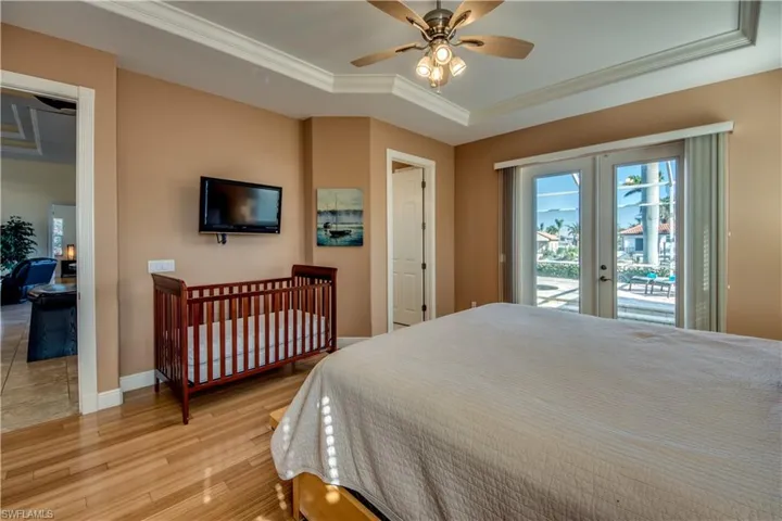 Bedroom with ceiling fan, french doors, light wood-type flooring, access to outside, and ornamental molding