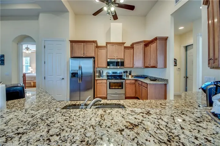 Kitchen featuring light stone countertops, sink, and stainless steel appliances