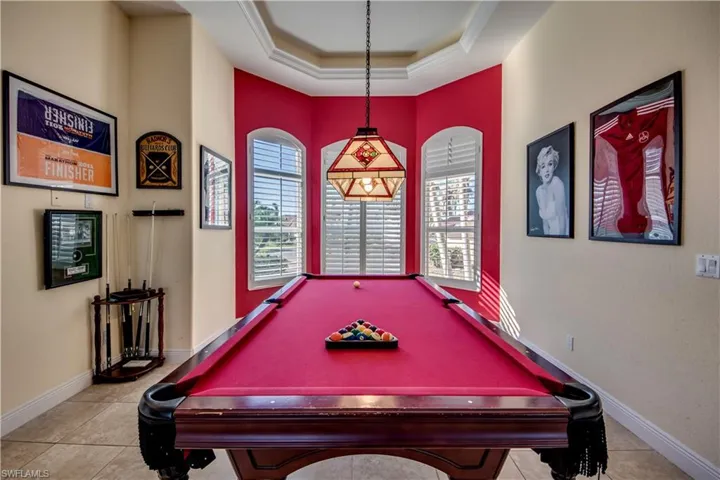 Game room with light tile patterned flooring, crown molding, and a tray ceiling