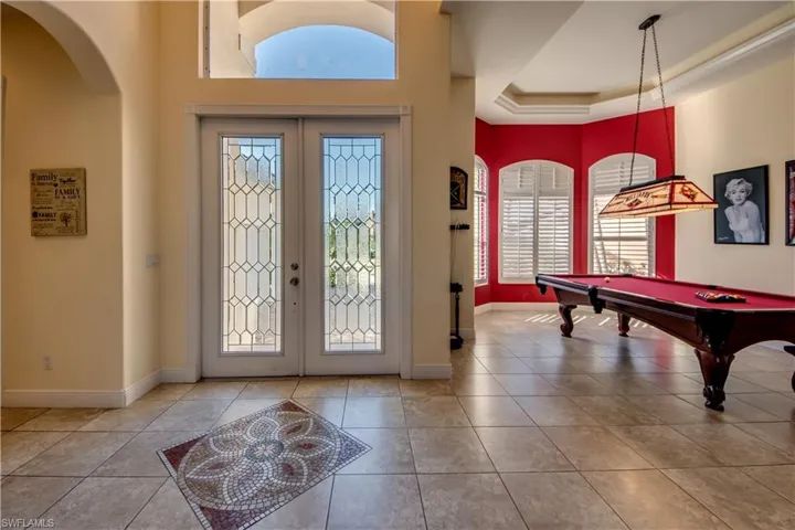 Entryway with french doors, a raised ceiling, light tile patterned floors, and a wealth of natural light