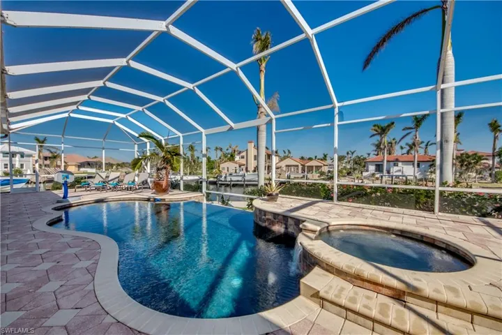 View of swimming pool with an in ground hot tub, a patio area, and a lanai