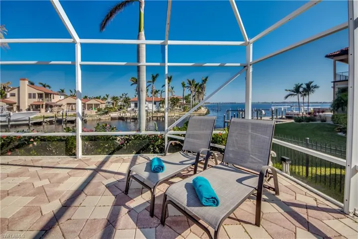 View of patio / terrace featuring glass enclosure and a water view