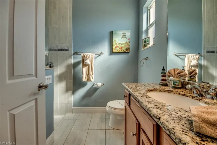 Bathroom with toilet, vanity, and tile patterned floors