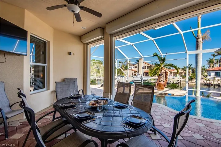View of patio with glass enclosure and ceiling fan