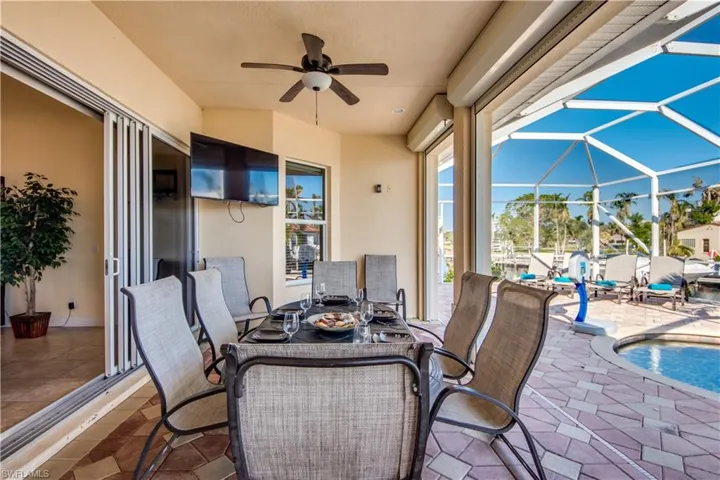 View of patio with glass enclosure and ceiling fan