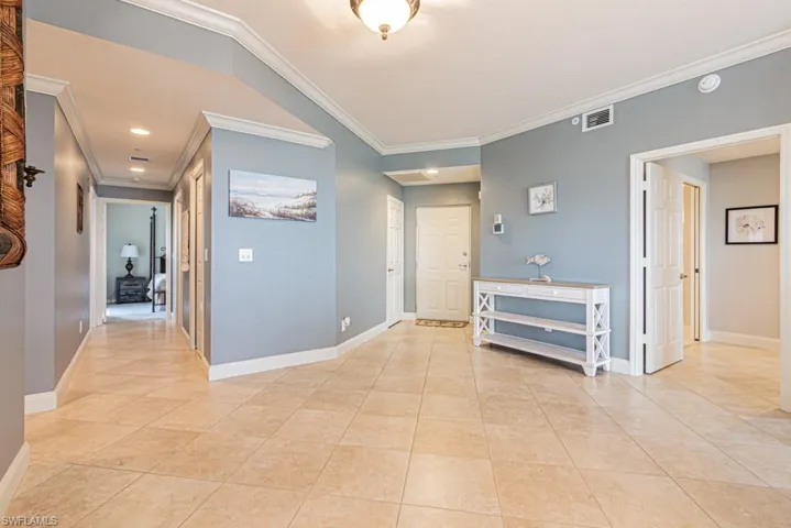 Corridor featuring crown molding, light tile patterned floors, and recessed lighting