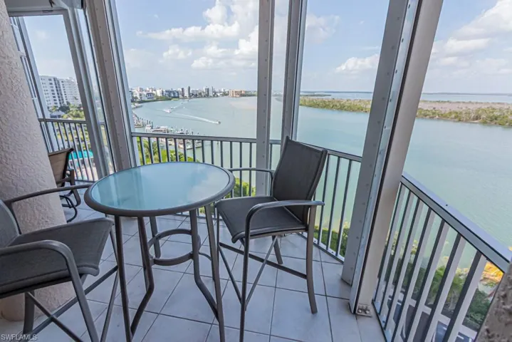 Balcony featuring a water view and a sunroom