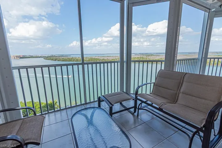 Sunroom / solarium featuring a water view, healthy amount of natural light, and floor to ceiling windows