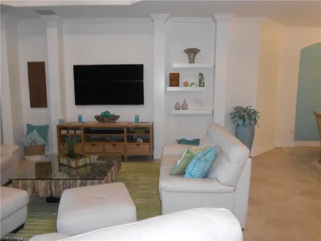 Living area featuring crown molding and built in shelves