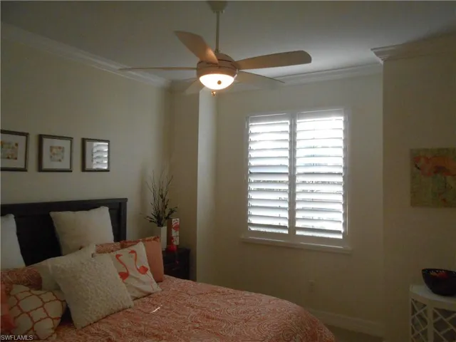 Bedroom with ornamental molding and a ceiling fan