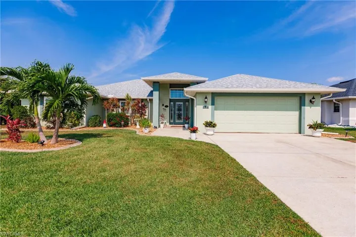 View of front facade featuring a garage and a front lawn