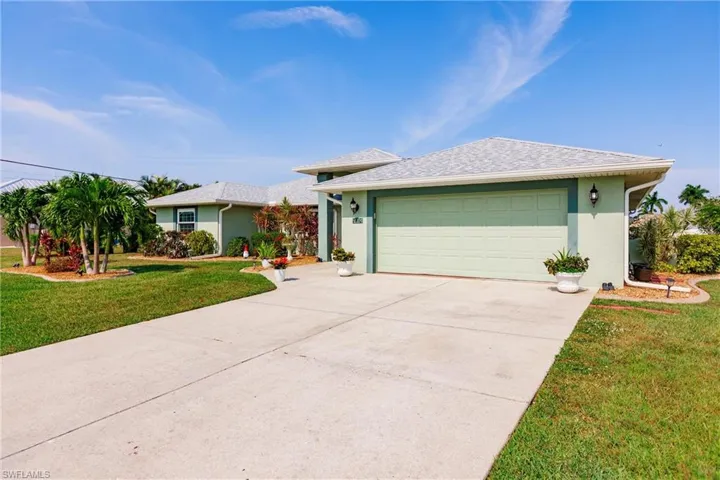 Ranch-style house with a garage and a front lawn