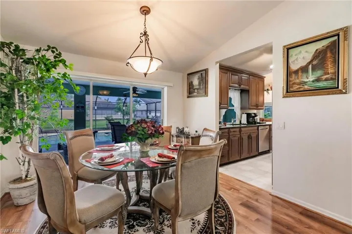 Dining room featuring sink, lofted ceiling, and light tile floors