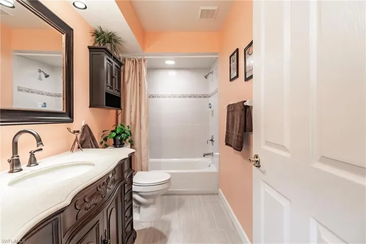 Full bathroom with tile flooring, shower / tub combo, vanity, and toilet