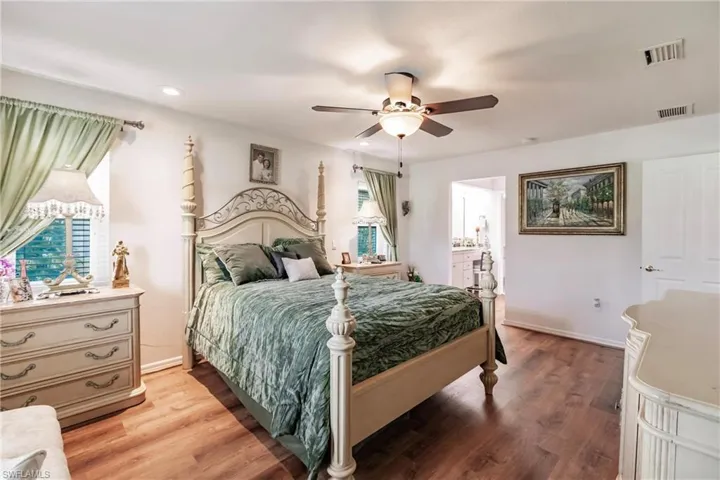 Bedroom featuring connected bathroom, ceiling fan, and hardwood / wood-style floors