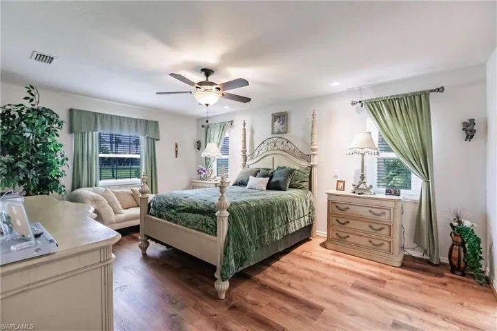 Bedroom featuring hardwood / wood-style flooring, multiple windows, and ceiling fan