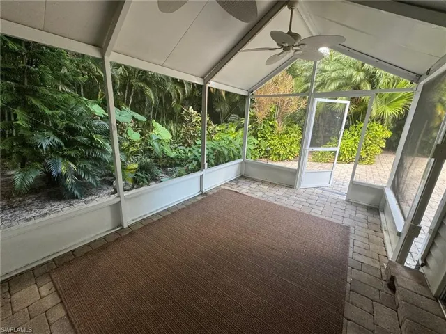 Unfurnished sunroom featuring lofted ceiling with beams and ceiling fan