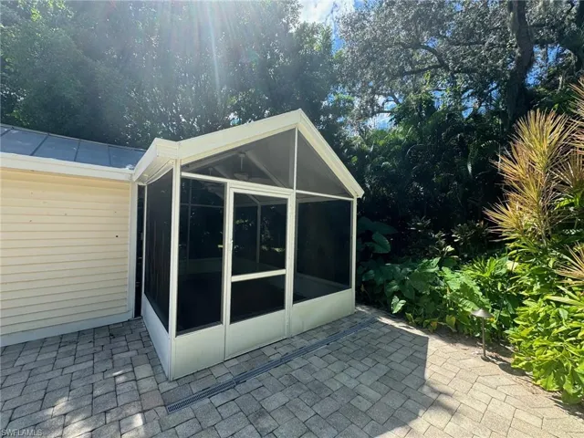 View of side of property featuring a sunroom and a patio