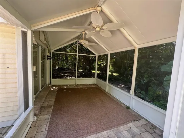 Unfurnished sunroom featuring lofted ceiling and ceiling fan