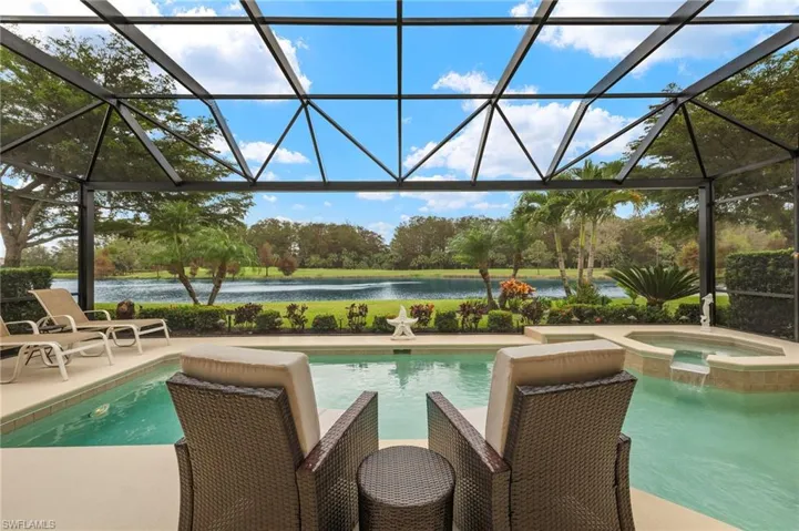 View of pool featuring a lanai, a water view, an in ground hot tub, and a patio area