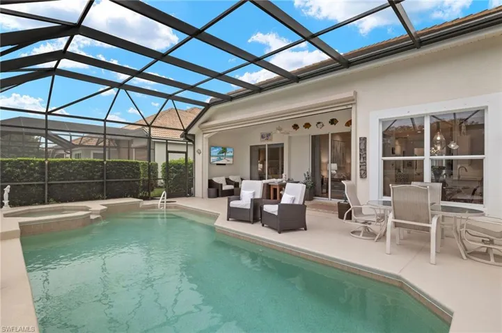 View of pool featuring a lanai, an outdoor living space, an in ground hot tub, and a patio area