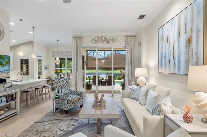 Living room featuring sink, light tile patterned floors, and ornamental molding
