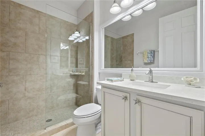 Bathroom with walk in shower, vanity, and toilet