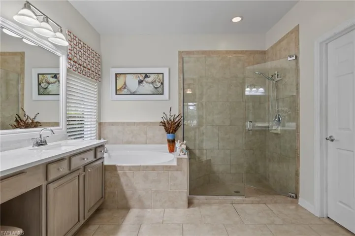 Bathroom with tile patterned flooring, vanity, and independent shower and bath