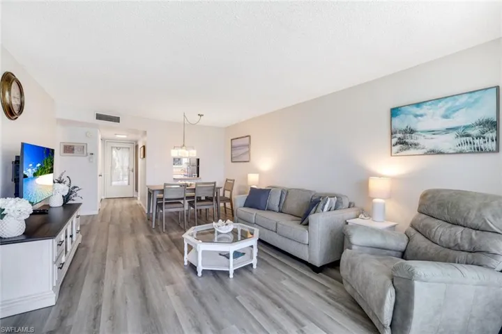 Living room with light wood-type flooring and a textured ceiling