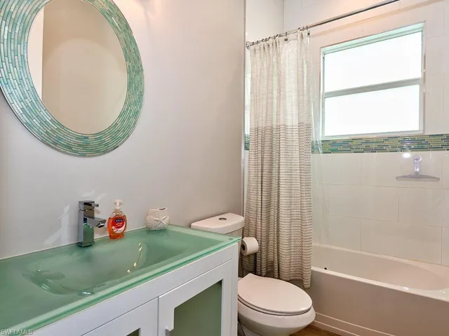 Full bathroom with shower / bath combination with curtain and vanity