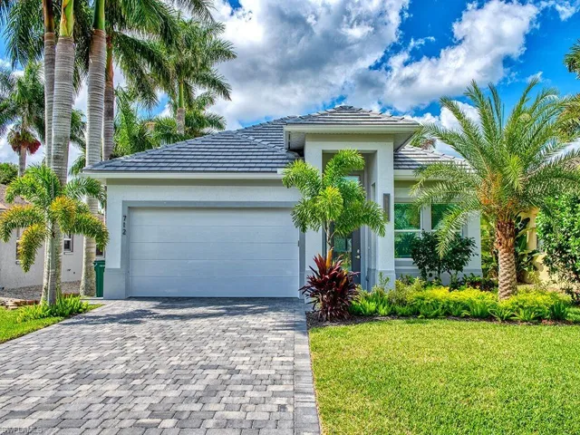 View of front of property featuring stucco siding, a front lawn, decorative driveway, a tile roof, and an attached garage