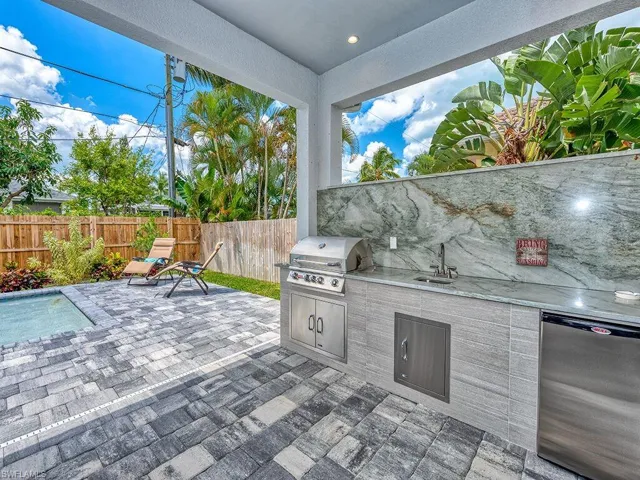 Fenced backyard with a patio and an outdoor kitchen
