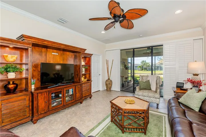 Living area with ceiling fan, ornamental molding, and visible vents
