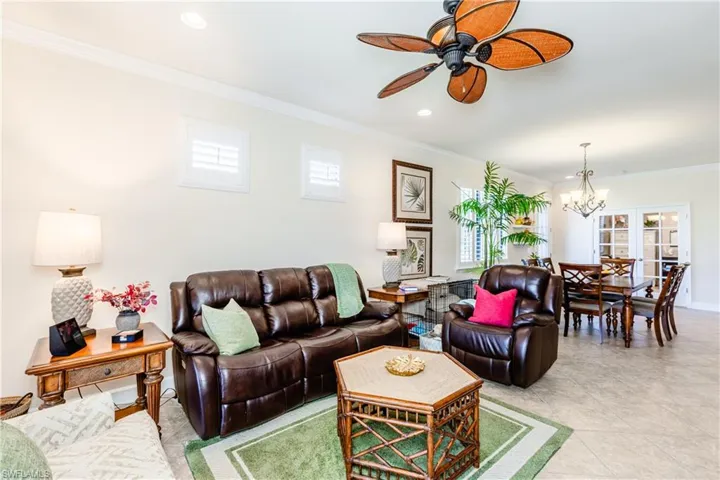 Living area featuring ceiling fan with notable chandelier, ornamental molding, and recessed lighting