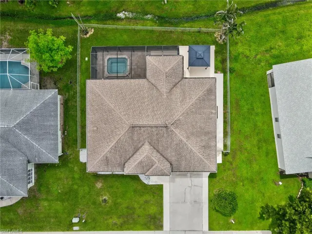 Residential property featuring an asphalt shingle roof, a screened-in spa, and a rear gazebo