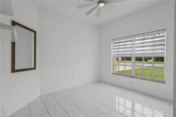 Recessed lighting with a ceiling fan, large window with blinds, and white tile flooring