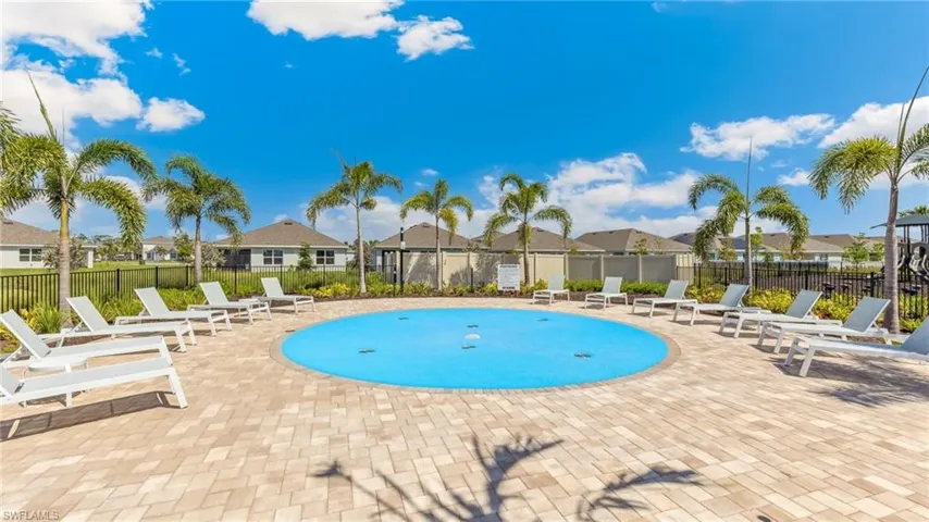 This property features a paved patio area with a circular water pad and surrounding lounge chairs